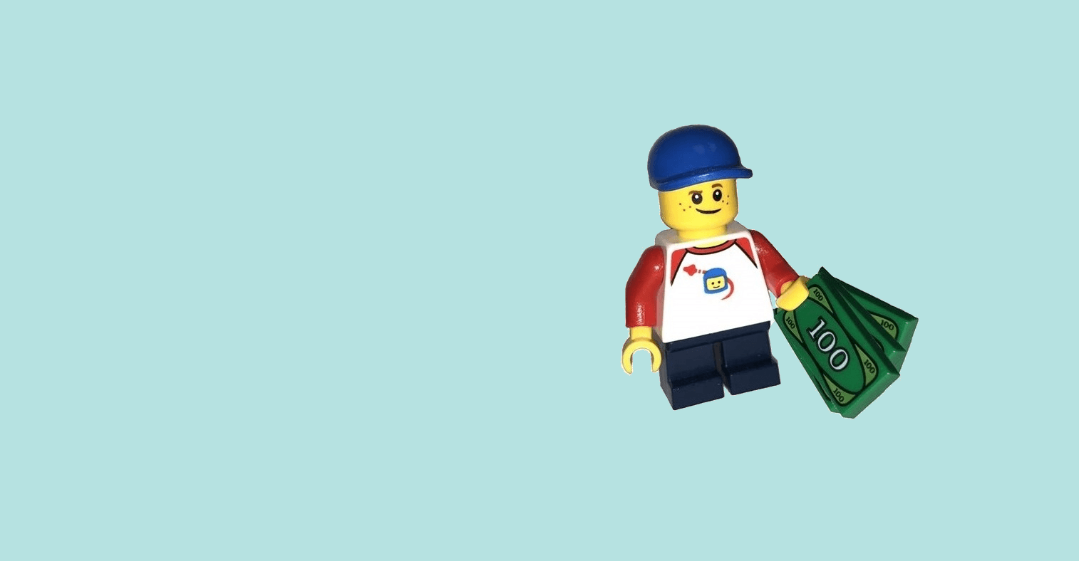 A LEGO boy holding some LEGO banknotes.